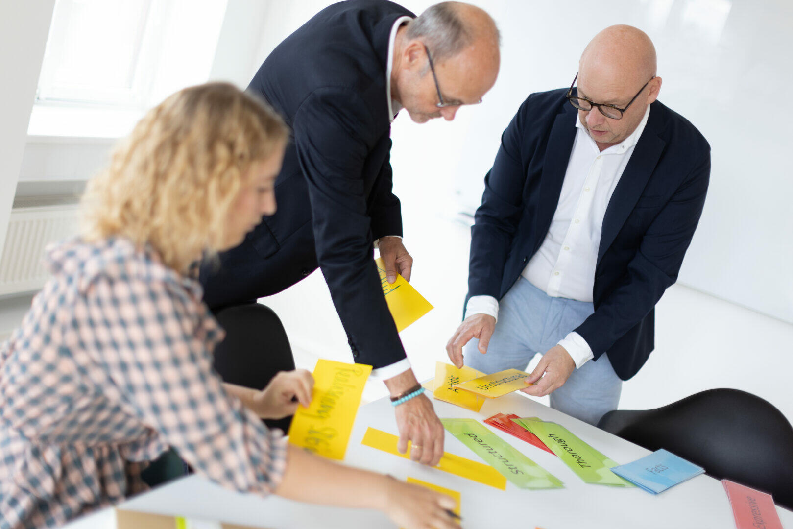 En gruppe forretningsfolk, der engagerer sig i organisationsudviklingsaktiviteter, mens de samarbejder om den regenerative projektlederuddannelse