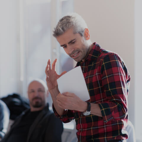 Andreas Lindemann i en plaidskjorte holder et stykke papir.