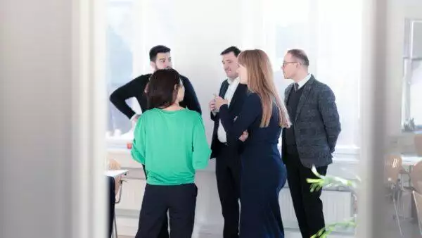 En gruppe forretningsfolk, der deltager i organisationsudviklingsdiskussioner på et kontor.