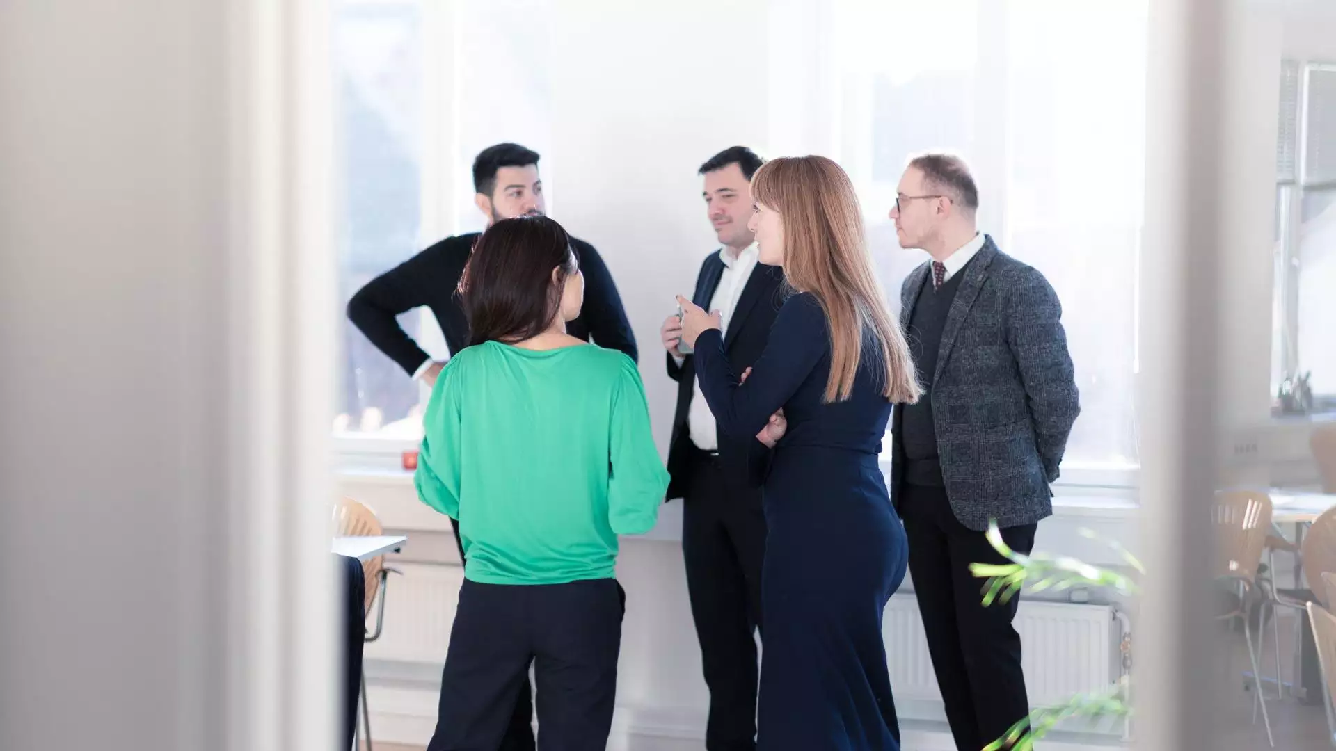 En gruppe forretningsfolk, der deltager i organisationsudviklingsdiskussioner på et kontor.