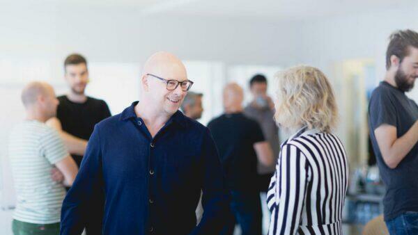 En gruppe mennesker på et kontor taler med hinanden.