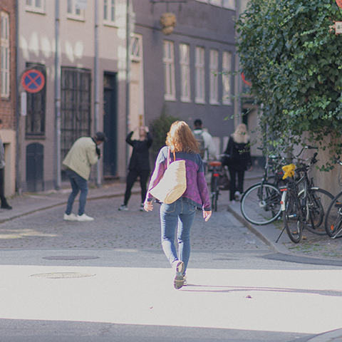 En kvinde, der går ned ad en gade i københavn en sommerdag